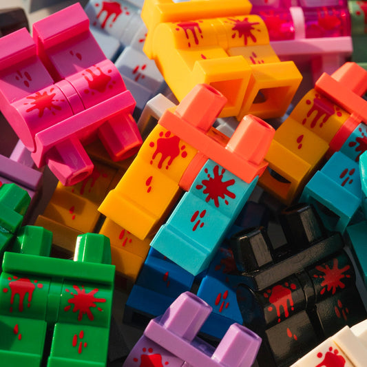 Colorful plastic building blocks with red splatter design on a close-up shot.