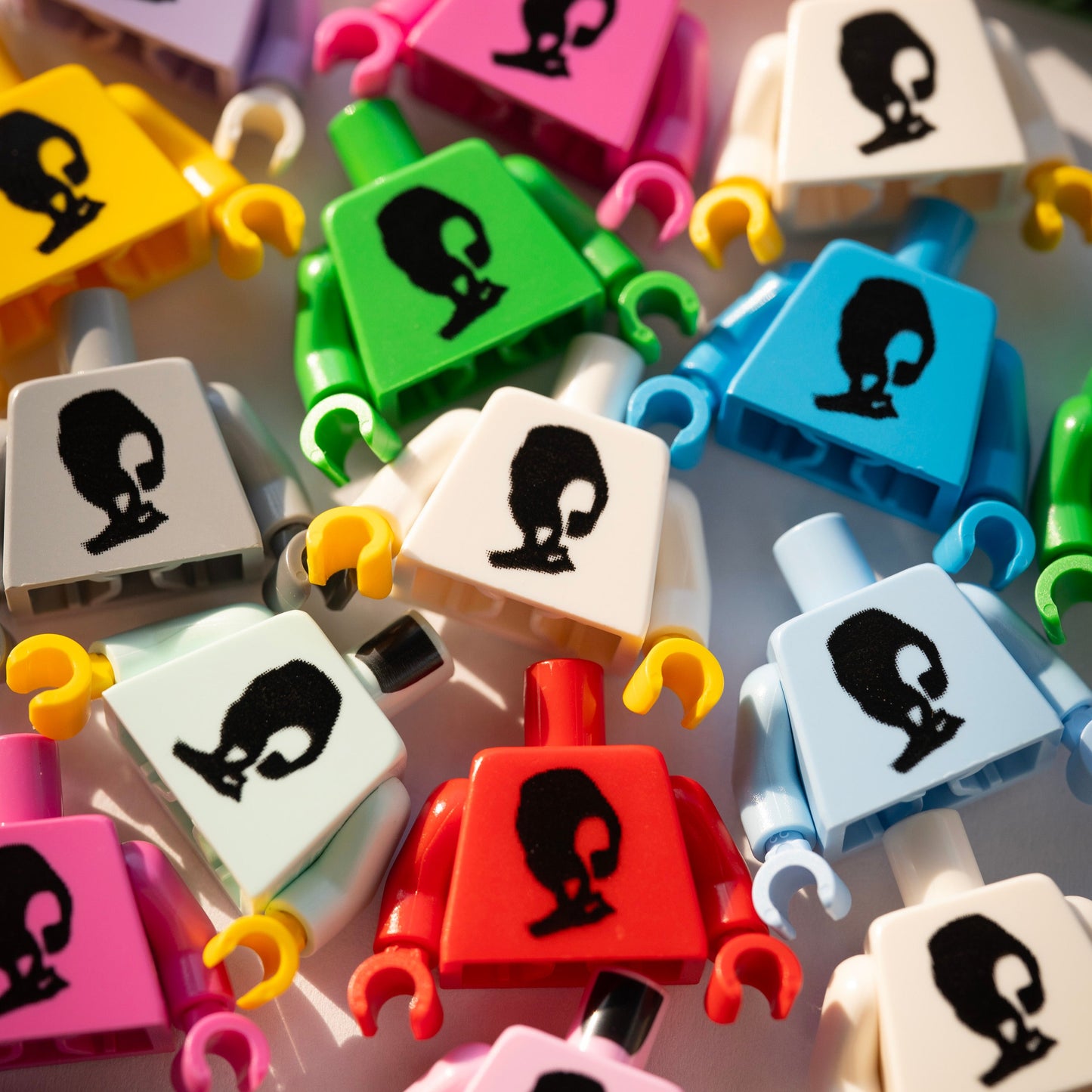 Colorful building block figures with black face designs on a white background