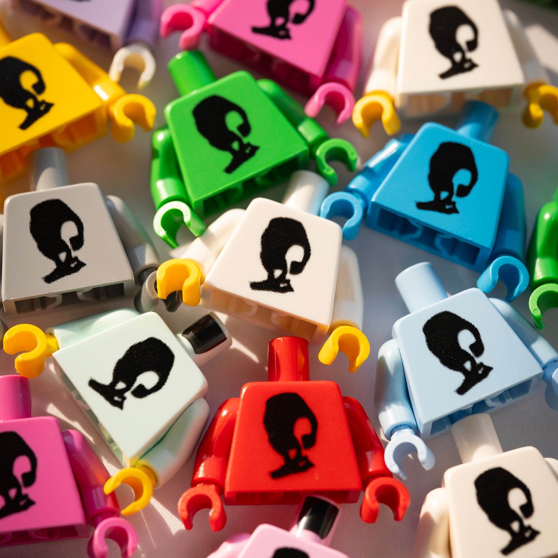 Colorful building block figures with black face designs on a white background